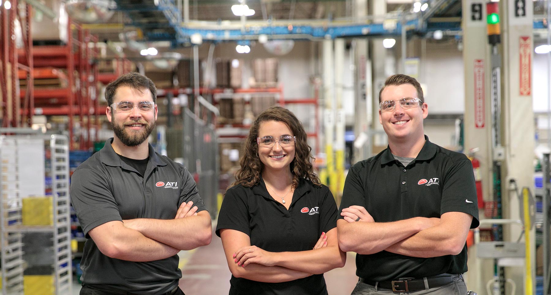 Three ATI team members at a factory