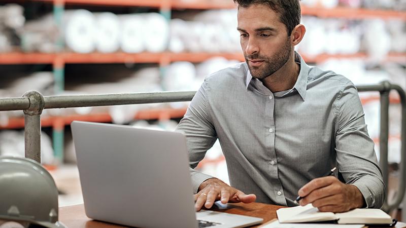 Benefits manager with a laptop at a factory